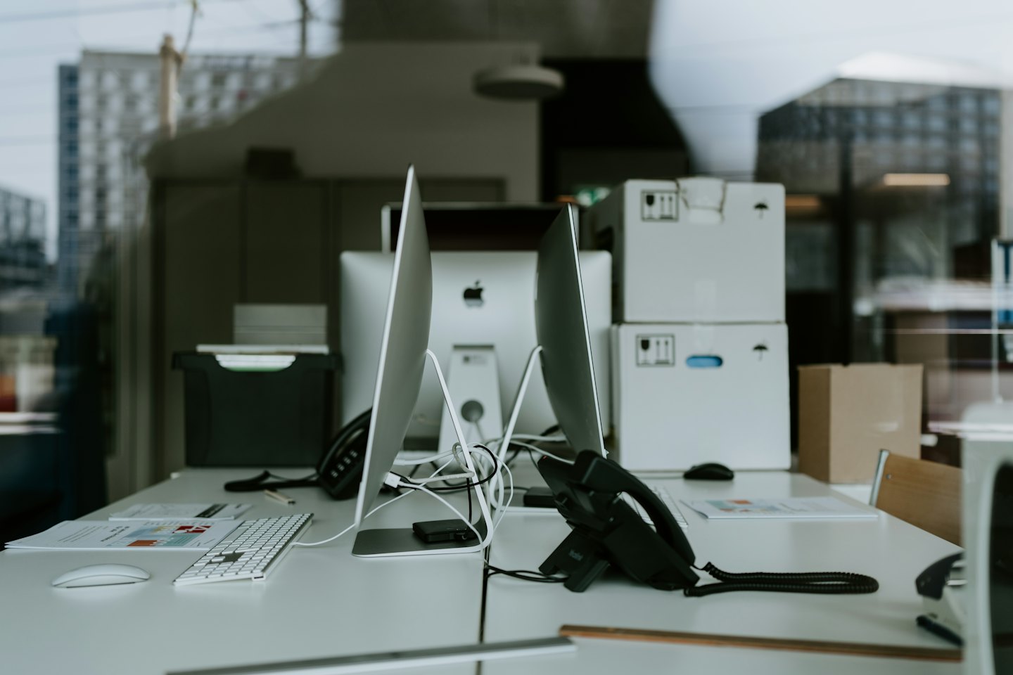 Scrivanie moderne con computer e telefoni in un ufficio.